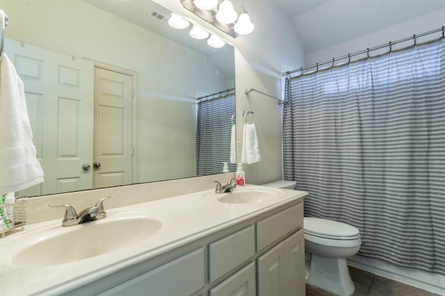 bathroom with tile patterned flooring, double vanity, toilet, and a sink