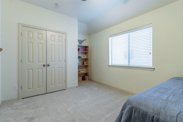 bedroom featuring a closet, baseboards, lofted ceiling, and carpet floors