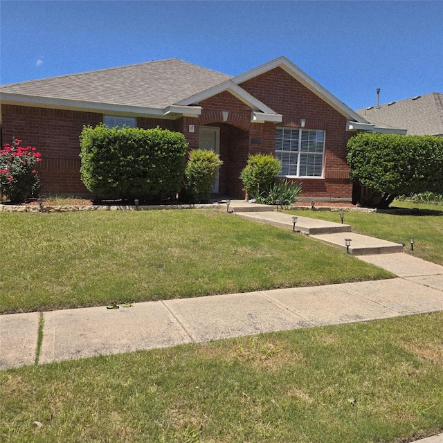 view of front of property featuring a front lawn and brick siding