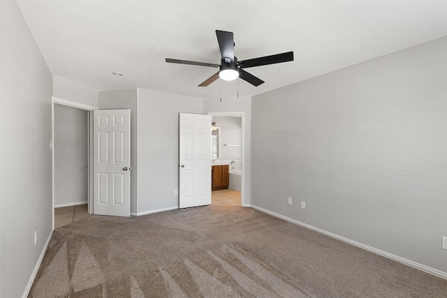 unfurnished bedroom featuring a ceiling fan, light colored carpet, baseboards, and ensuite bathroom