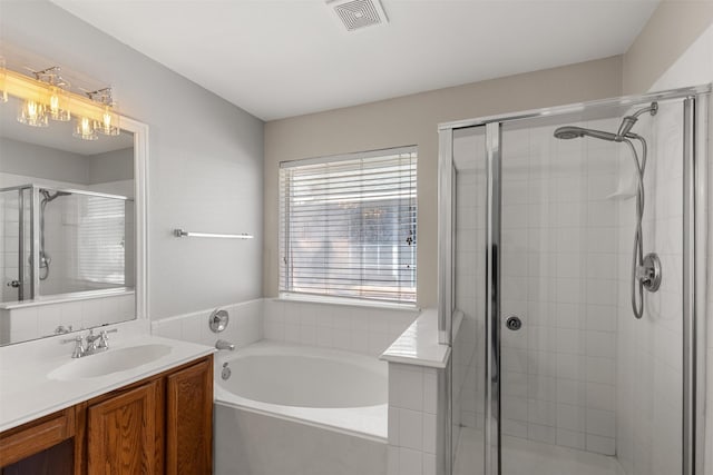 bathroom featuring visible vents, a garden tub, a stall shower, and vanity