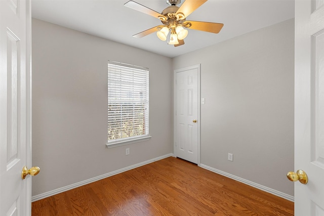 unfurnished room featuring ceiling fan, baseboards, and wood finished floors