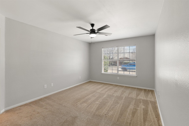 spare room featuring carpet flooring, baseboards, and ceiling fan