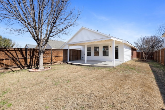 back of property with a fenced backyard, a patio, and a lawn