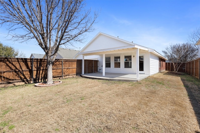 back of property with a patio area, a yard, and a fenced backyard