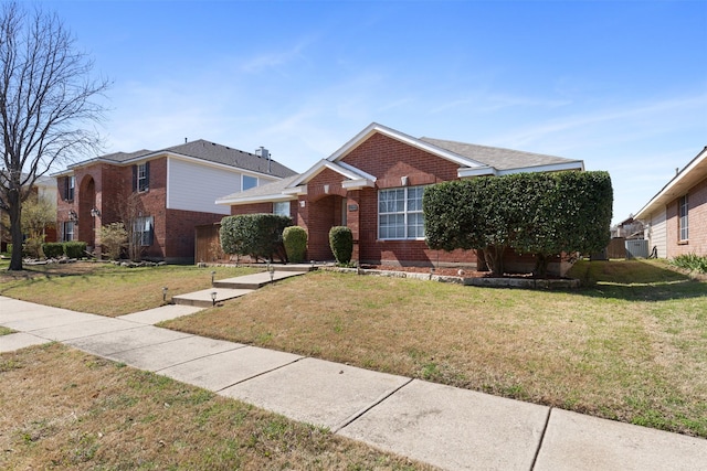 view of front of home featuring brick siding and a front yard