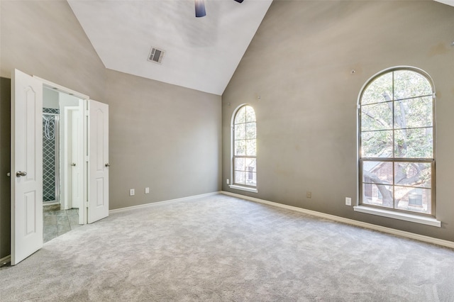 spare room featuring ceiling fan, carpet flooring, and high vaulted ceiling