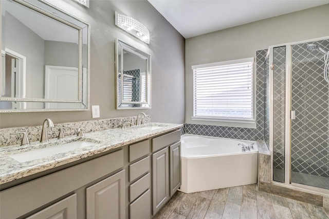 full bathroom featuring a sink, a garden tub, a stall shower, and double vanity