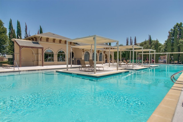 community pool with a patio and fence