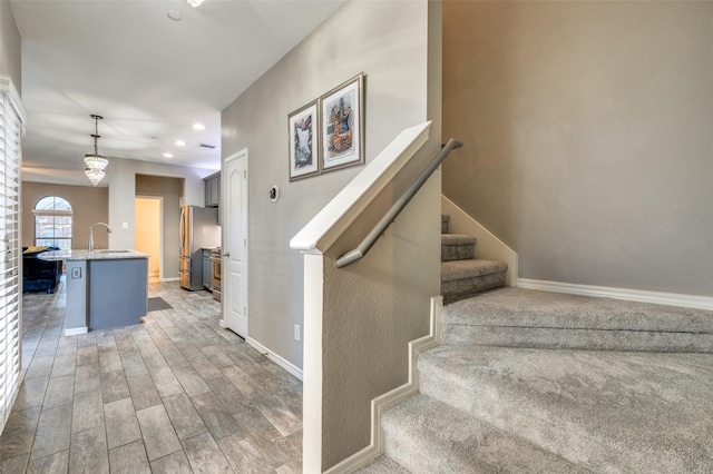 staircase with recessed lighting, baseboards, and wood finished floors