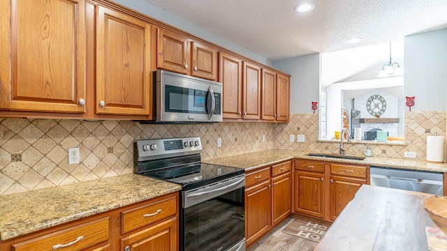 kitchen with brown cabinets, stainless steel appliances, and a sink