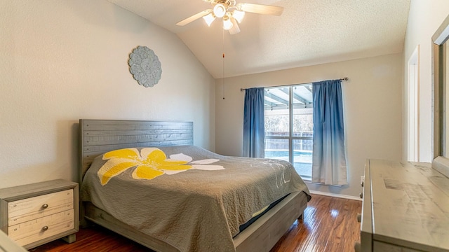 bedroom featuring dark wood-type flooring, lofted ceiling, a textured ceiling, baseboards, and ceiling fan