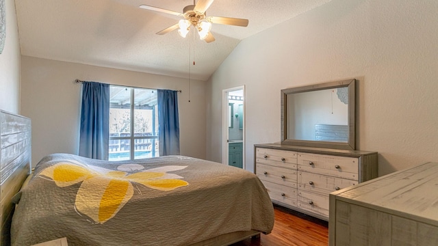 bedroom featuring wood finished floors, lofted ceiling, ceiling fan, ensuite bathroom, and a textured ceiling