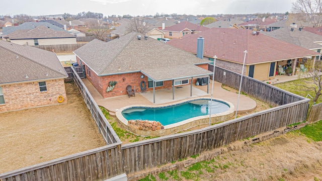 view of pool with a patio area, a fenced backyard, and a residential view