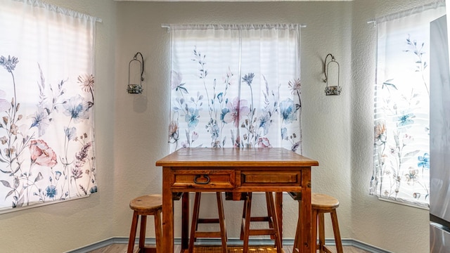 dining area featuring plenty of natural light and a textured wall