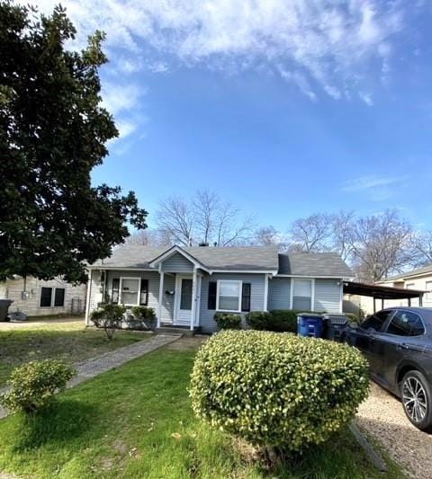 view of front of property featuring an attached carport and a front yard