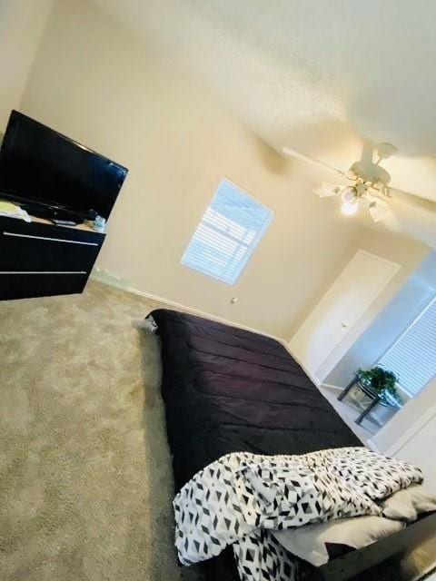 carpeted bedroom featuring baseboards and ceiling fan