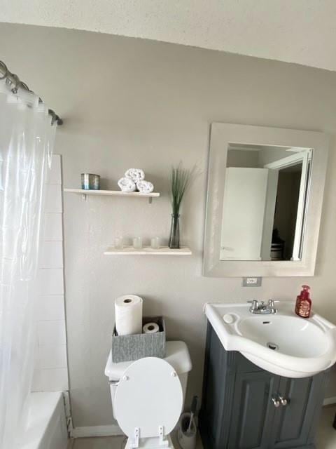 bathroom featuring shower / tub combo with curtain, toilet, and vanity