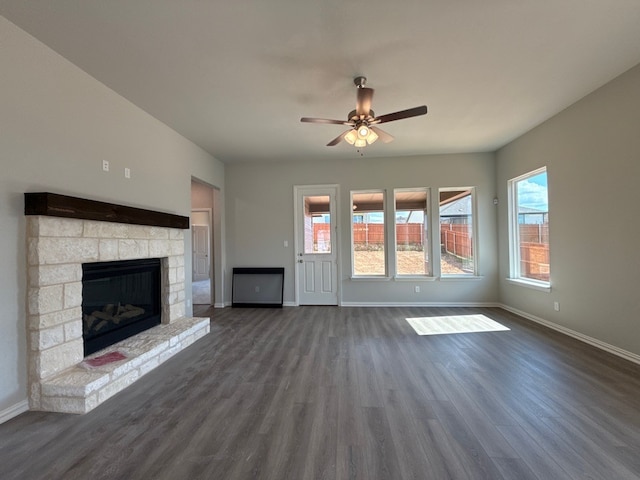 1412 Cedar Trl, Azle, TX 76020 - unfurnished living room with dark wood-style floors, baseboards, a ceiling fan, and a stone fireplace