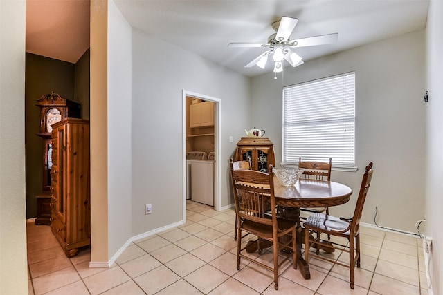 dining space with light tile patterned flooring, washer and dryer, baseboards, and a ceiling fan