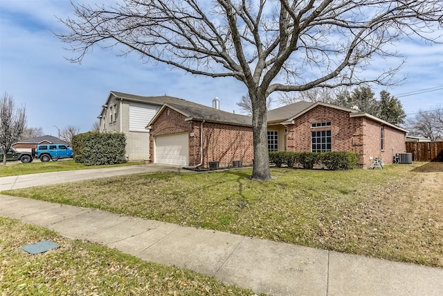 view of front of house with a front yard, driveway, an attached garage, central AC, and brick siding