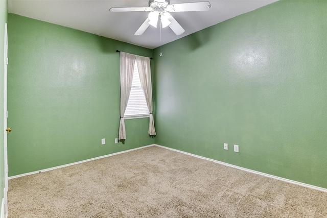 carpeted empty room with baseboards and a ceiling fan