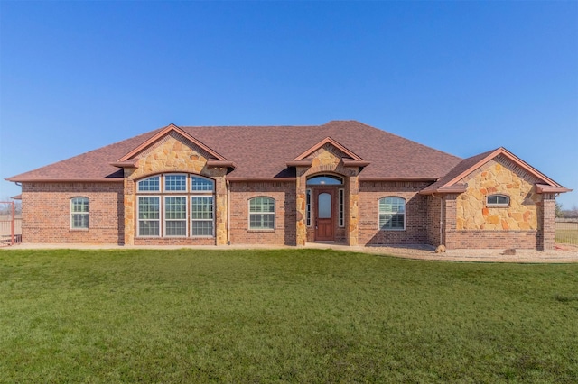 view of front of property with a front lawn, brick siding, and stone siding