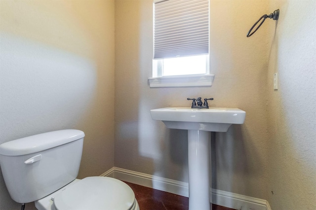 bathroom featuring toilet and baseboards