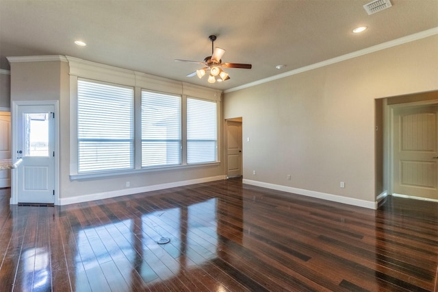 spare room with dark wood-style floors, visible vents, plenty of natural light, and crown molding