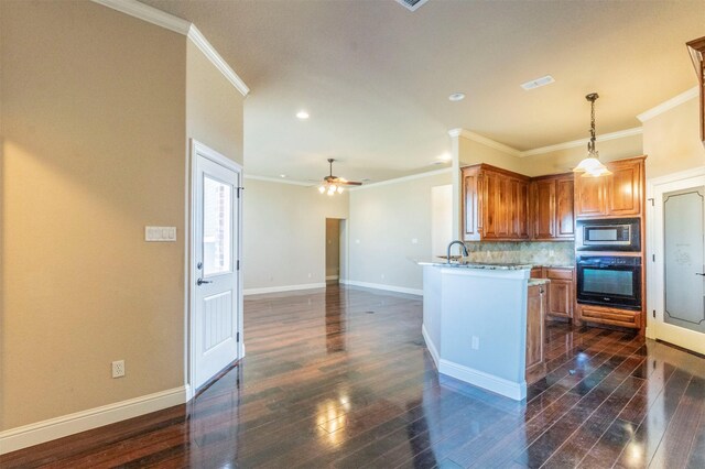 kitchen featuring dark wood-style floors, baseboards, decorative backsplash, stainless steel microwave, and black oven