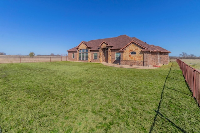 view of front of property with brick siding, a front yard, and fence