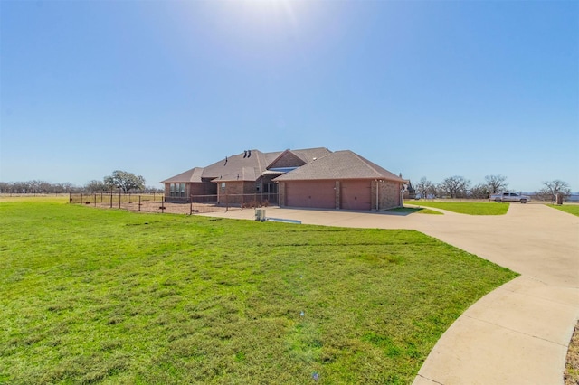 view of yard featuring an attached garage and fence