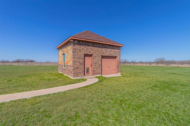 exterior space featuring a lawn, a shingled roof, brick siding, and a rural view