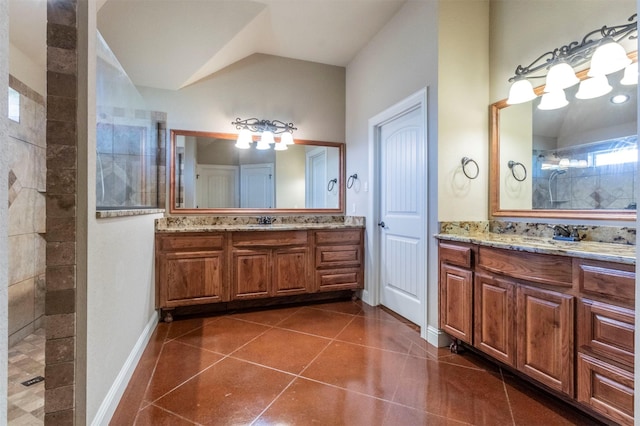 full bathroom with two vanities, a sink, tile patterned flooring, vaulted ceiling, and walk in shower