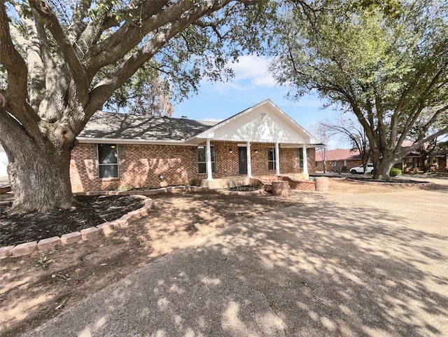 neoclassical / greek revival house with brick siding and a porch