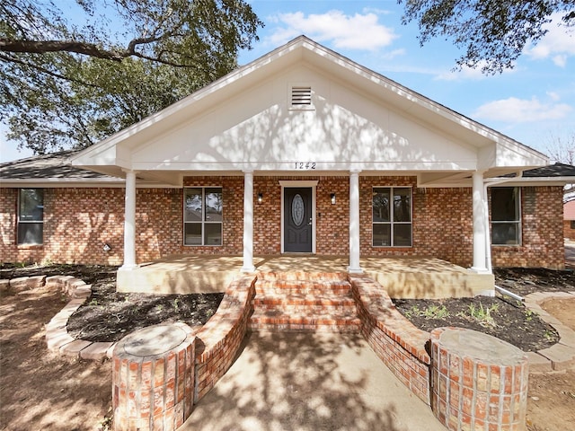 view of front of house featuring brick siding and a porch