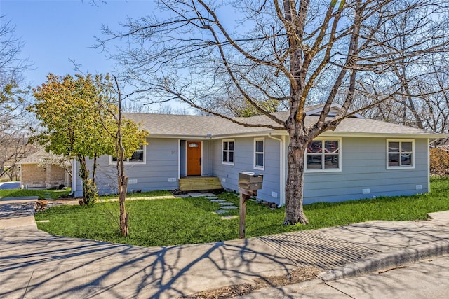 ranch-style home featuring a shingled roof, a front yard, and crawl space