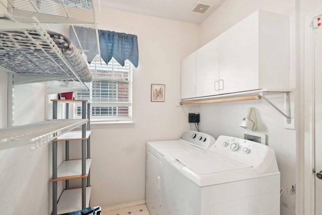 laundry area featuring visible vents, cabinet space, baseboards, and washing machine and clothes dryer