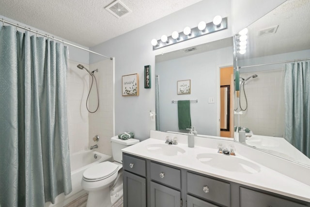 bathroom with a textured ceiling, visible vents, and a sink