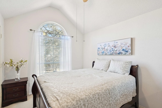 bedroom with ceiling fan, vaulted ceiling, and light carpet