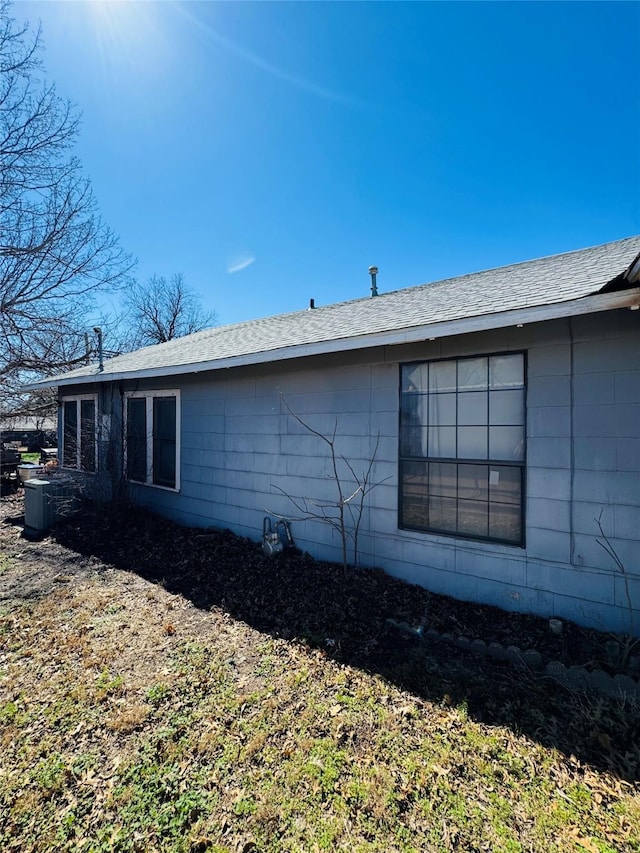 view of side of property featuring roof with shingles