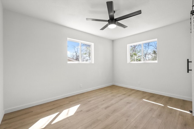 spare room featuring ceiling fan, baseboards, and light wood-style flooring