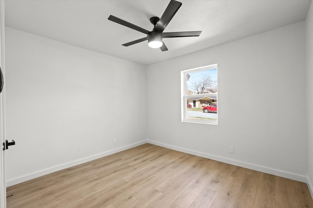 empty room featuring baseboards, light wood-style floors, and a ceiling fan