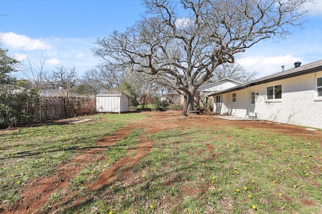 view of yard with an outbuilding, a shed, and fence