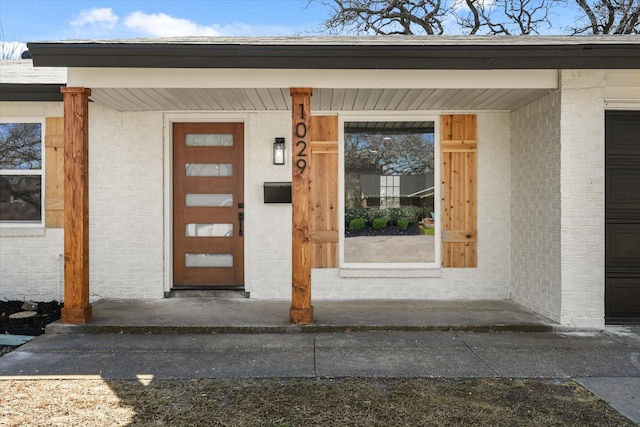 doorway to property featuring brick siding