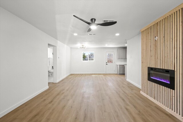 unfurnished living room with visible vents, ceiling fan, baseboards, and light wood-style floors