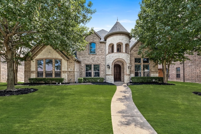 french country style house featuring a front yard, brick siding, and stone siding