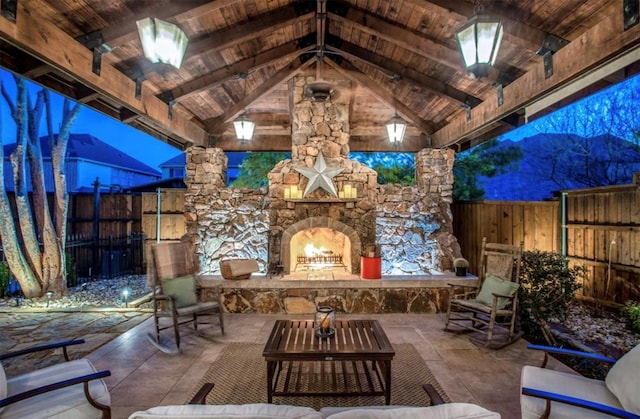 view of patio with an outdoor living space with a fireplace and fence