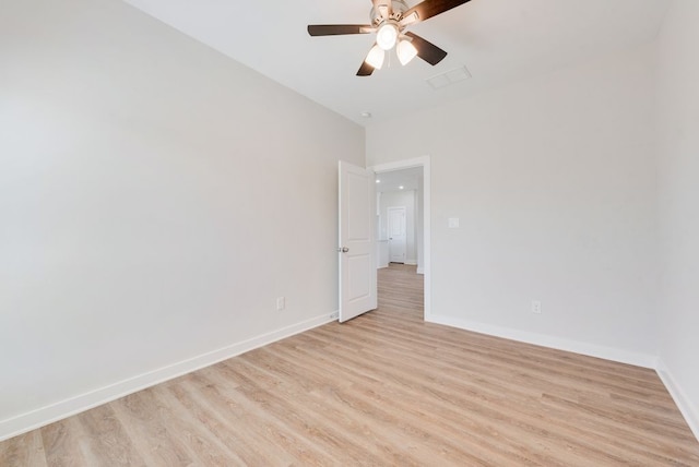 spare room with light wood-type flooring, baseboards, visible vents, and ceiling fan