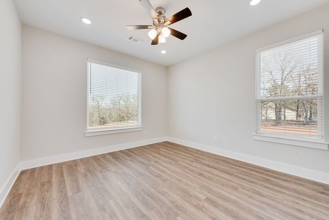 unfurnished room featuring visible vents, light wood-style floors, and baseboards